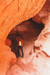 photographer standing inside cave taking picture