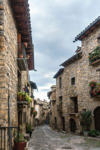 narrow main Street of historical center of Ainsa flanked by stone houses